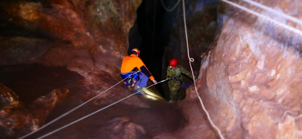 Australian Army soldier Warrant Officer Class Two Aaron Haining guides an Army cadet from 223 Army Cadet Unit Leeton as she abseils into a cavern at Wee Jasper, NSW, on 4 March 2016.