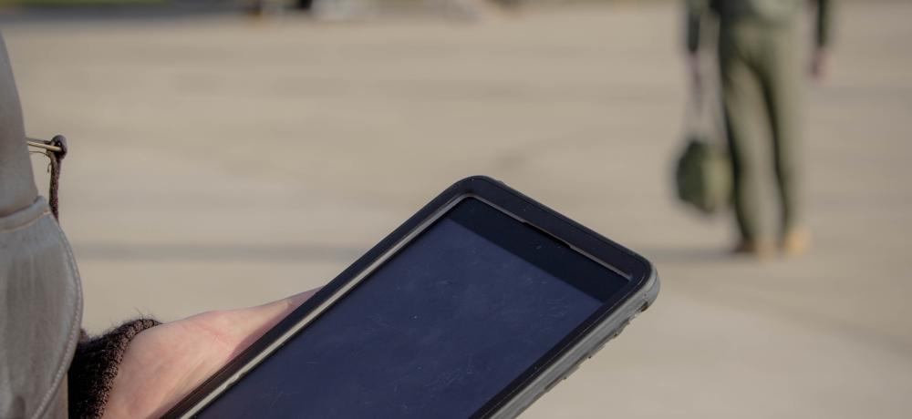 Flying Officer Charlie Goodacre checks mission data on an IPAD before a sortie on the P-8A Poseidon out of RAAF Base Edinburgh.