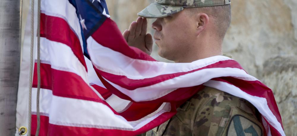 A US Army soldier from the 1st Cavalry Division salutes during the US national anthem during the Train, Advise, Assist Command - South Transfer of Authority ceremony.