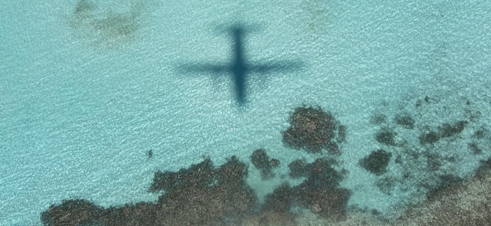 The shadow of a C-27J Spartan aircraft flying over the crystal clear waters of the Solomon Islands as part of a mission in search for illegal fishing vessels during Operation Solania.