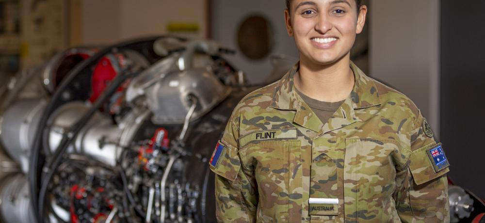 Third year aeronautical engineering student Officer Cadet Sarah Flint stands in front of a Rolls Royce aircraft jet engine in the engineering building at the Australian Defence Force Academy in Canberra.