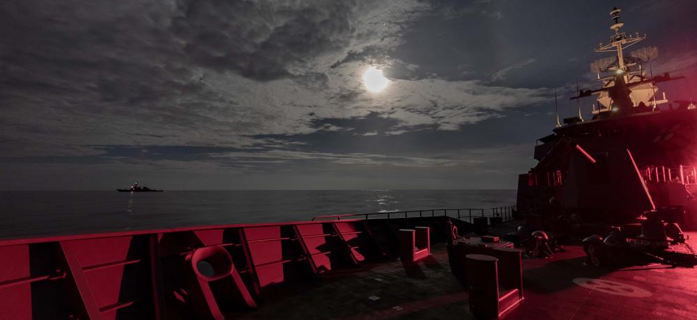 HMAS Ballarat sails under a full moon with USS John S. McCain en route to Exercise Malabar 2020.