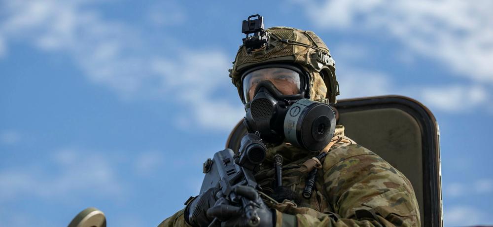 Sapper Floyd Huxley from the 2nd Combat Engineer Regiment sentries from an Australian Army Protected Mobility Vehicle while wearing the new Australian Defence Force Low Burden Mask and accompanying protective kit during a simulated chemical, biological, radiological, nuclear survival training… read more