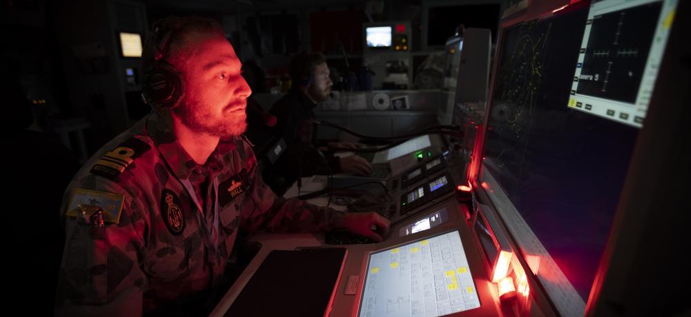 Principal Warfare Officer, Lieutenant Commander Stephen Wall, in the operations room onboard HMAS Warramunga, during a maritime patrol in support of Operation ARGOS.