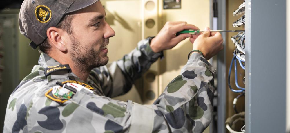 Leading Seaman Electronics Technician Andrew Nortcliffe conducts maintenance on a server on board HMAS Brisbane during a Regional Presence Deployment.