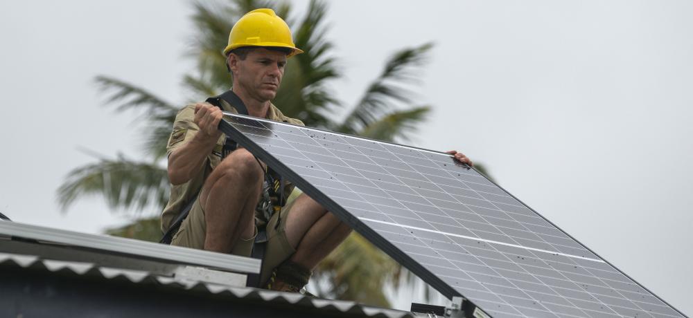 Australian Army Corporal Bradley Geeves installs a solar panel on the Tongoa Island Police Post during the Vanuatu Government National Emergency Radio Network project.