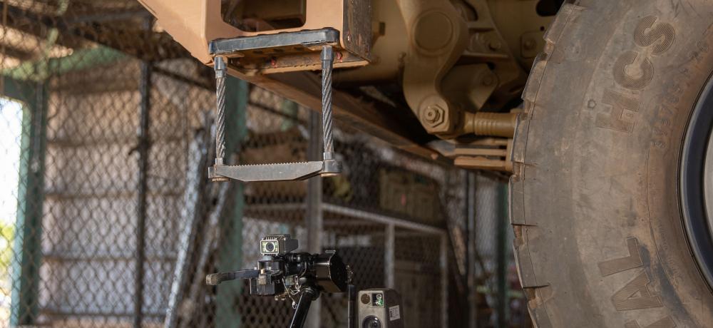 A Squad Packable Utility Robot drives under a 40M Medium Ridged Truck from EPE during a trial at Robertson Barracks, Northern Territory.