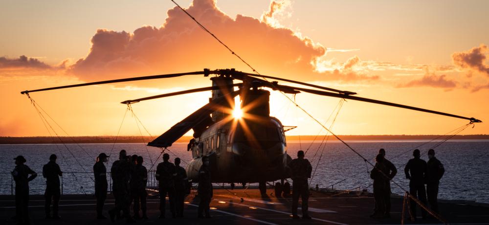 An Australian Army CH-47F Chinook helicopter at sunset onboard HMAS Adelaide during Operation Tonga Assist 2022.