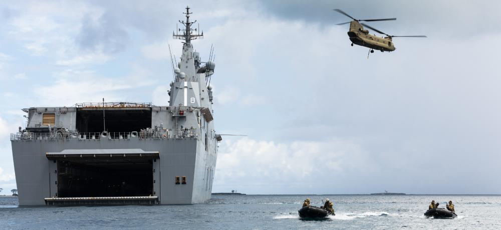 Australian Army soldiers from 2nd Battalion, Royal Australian Regiment, conduct amphibious operations in Zodiac inflatable boats as a CH-47F Chinook helicopter takes-off from HMAS Canberra off the coast of Nomuka Island, Tonga, during Operation Tonga Assist 2022.