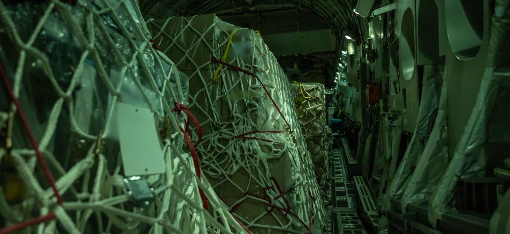 A night-time view inside the dimmed cargo hold of a Royal Australian Air Force C-17A Globemaster III carrying Australian and New Zealand defensive military assistance supplies bound for a European airport, where the load will be forwarded to the Ukrainian Government