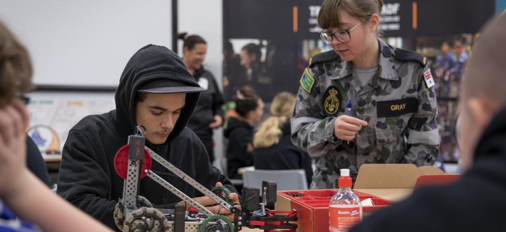 Seaman Communications and Information Systems Kayla Gray helps students from Glendale Technology High School with an interactive exercise during Navy Immersion Day at the Centre for Innovation, Garden Island Defence Precinct, NSW.