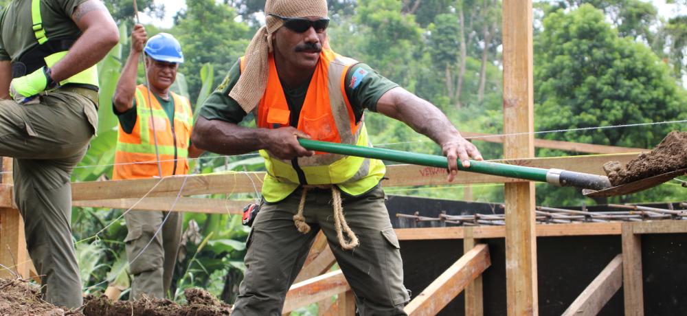 A Republic of Fiji Military Forces engineer makes light work of a trench while constructing a footbridge alongside Australian Army engineers at Queen Elizabeth Barracks in Suva, Fiji, as part of Exercise Coral Sapper 2022.