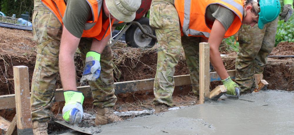 Australian Army soldiers Sapper Luke Zakulis (left) and Sapper Madison Lewis from 2nd Combat Engineer Regiment screed concrete for a footbridge at Nabuni Barracks in Suva, Fiji, as part of Exercise Coral Sapper.