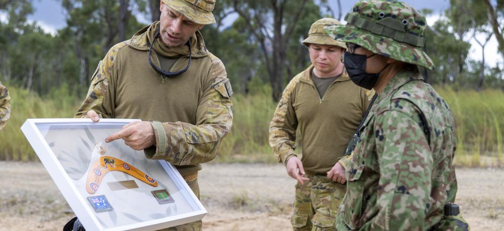 Australian Army officer Lieutenant Colonel Richard Niessl from 6th Battalion, Royal Australian Regiment hands a gift to Japanese Ground Self Defence Force Colonel Kagami Mori at Shoalwater Bay training area, Queensland, as part of Exercise Southern Jackaroo 2022.