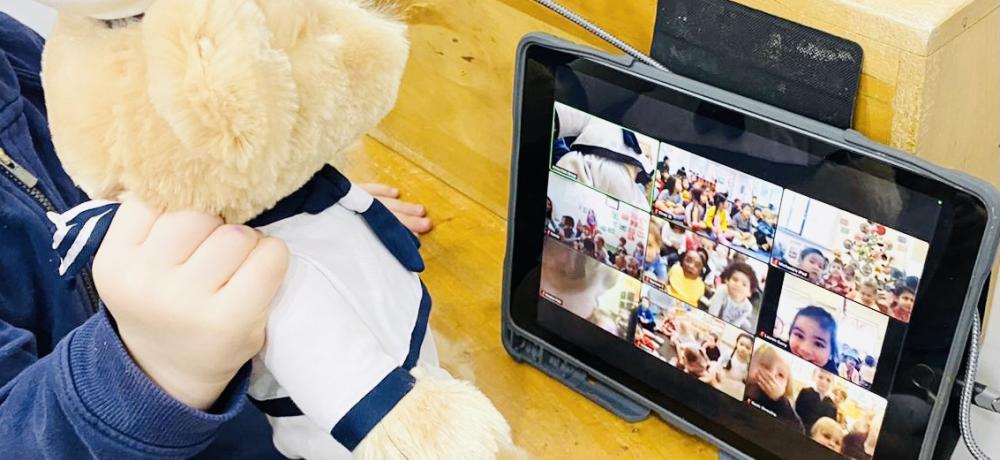 A Royal Australian Navy teddy is held by a child from the Vaucluse Cottage Childcare Centre in Sydney, New South Wales, during a Zoom call to sister preschools.