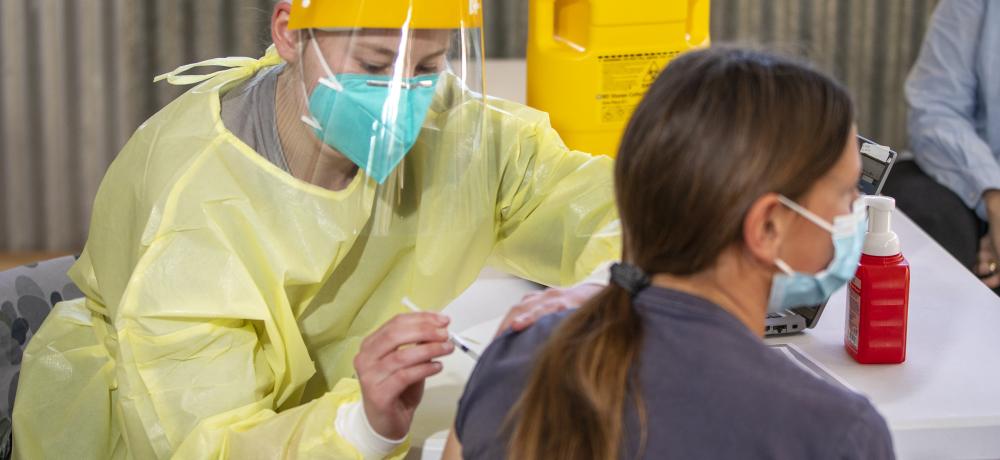 Royal Australian Navy Medic, Seaman Alana Leonard from HMAS Penguin, administers a COVID-19 vaccination at Vaccination Outreach Clinic at the Nyngan Showgrounds, New South Wales.