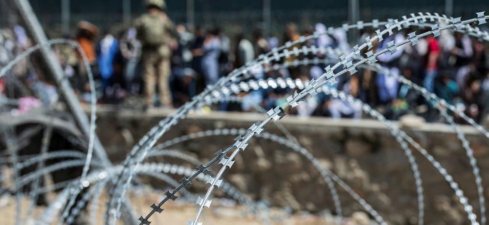 Afghans show their passports and credentials to multi national service personnel in an attempt to leave Afghanistan through the congested Abbey Gate at Hamid Karzai International Airport.