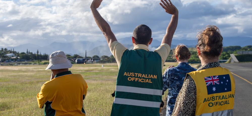 Australian officials watch an RAAF Hercules Magenta Airport in Noumea, New Caledonia. 