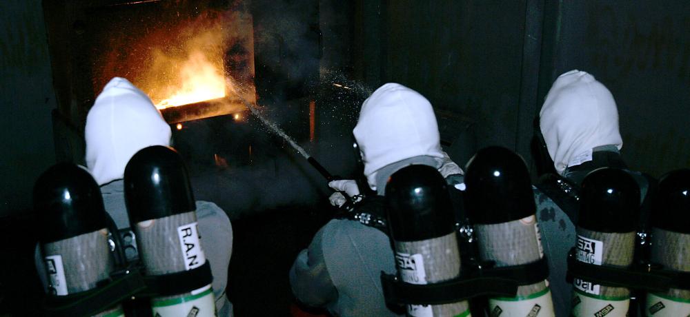 Royal Australian Navy School of Survivability and Ship Safety. Captains cabin simulated fire being attacked by BA (Breathing Apparatus) attack party.
