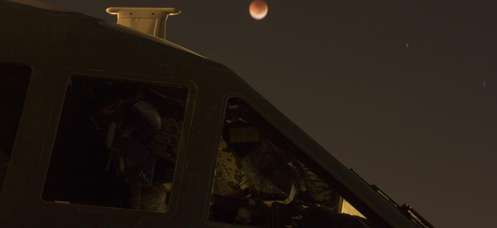 A 'blood moon' lunar eclipse behind a Royal Australian Air Force No. 35 Squadron C-27J Spartan aircraft, on the flight line at RAAF Base Darwin during Exercise Pitch Black 2018.