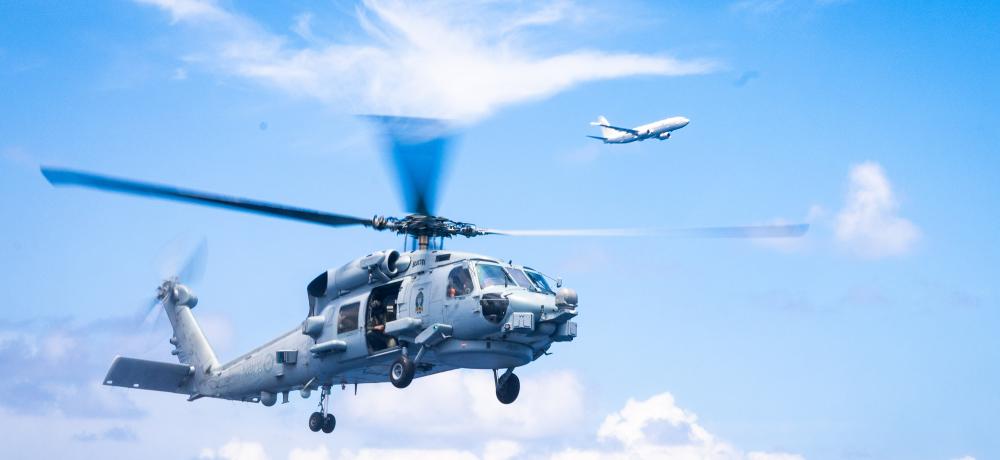 HMAS Sydney's MH-60R Seahawk and a New Zealand Air Force P-8A Poseidon aircraft fly over HMAS Sydney on a routine surveillance flight in the Indo-Pacific region during Regional Presence Deployment 25-2.
