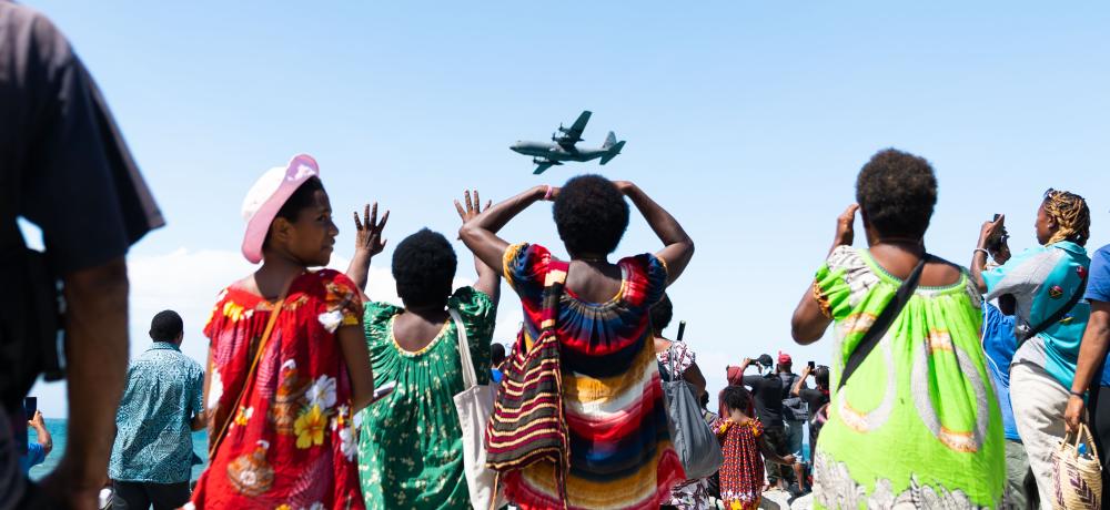 Crowds at Ela Beach watch as a Royal Australian Air Force C-130J Hercules conducts a fly past as part of the Ela Beach Air Show in Papua New Guinea.