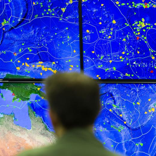 Royal Australian Air Force Squadron Leader Robert Crawford reviews a map displaying the location of known fishing vessels during a brief held at the Forum Fisheries Agency, Regional Fisheries Surveillance Centre in Honiara, Solomon Islands, as part of Operation Solania.