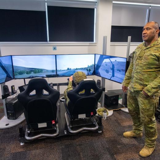 Australian Army Corporal Enele Ma’afu (right), from the 7th Combat Service Support Battalion, supervises his troop while they conduct tactical driver training and Standard Operating Procedure rehearsals using the Virtual Driver Training Simulator at Gallipoli Barracks, Brisbane.