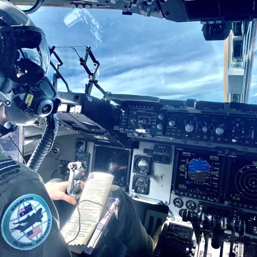 A Royal Australian Air Force pilot with No. 36 Squadron in the cockpit of a C-17A Globemaster aircraft during Exercise Global Dexterity 21. The helmet and oxygen mask are worn when performing selected airdrop profiles.