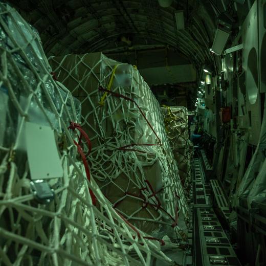 A night-time view inside the dimmed cargo hold of a Royal Australian Air Force C-17A Globemaster III carrying Australian and New Zealand defensive military assistance supplies bound for a European airport, where the load will be forwarded to the Ukrainian Government