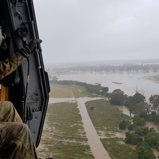 An Australian Army loadmaster from the Army Aviation Training Centre at Oakey in Queensland surveys flooding from an MRH-90 Taipan helicopter on Friday, 13 May 2022.