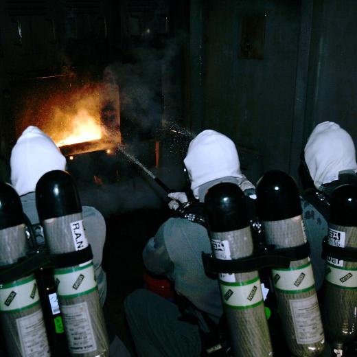 Royal Australian Navy School of Survivability and Ship Safety. Captains cabin simulated fire being attacked by BA (Breathing Apparatus) attack party.