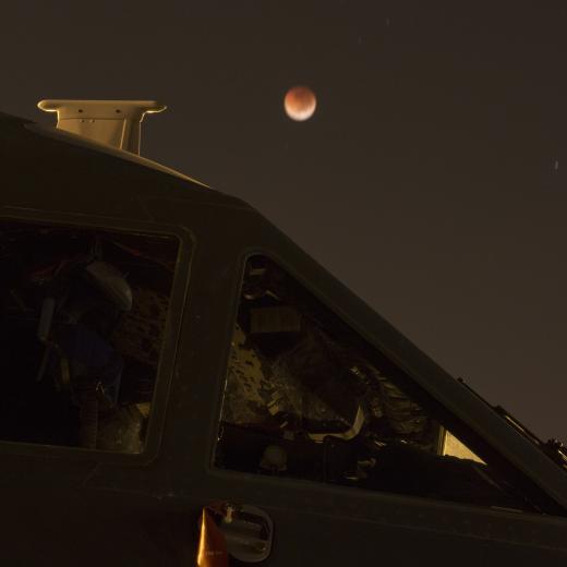 A 'blood moon' lunar eclipse behind a Royal Australian Air Force No. 35 Squadron C-27J Spartan aircraft, on the flight line at RAAF Base Darwin during Exercise Pitch Black 2018.
