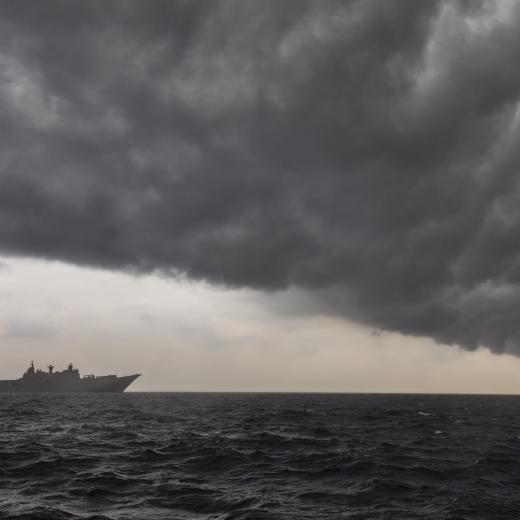 HMAS Adelaide sails into a rain cloud during Indo-Pacific Endeavour 2022.