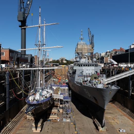 STS Young Endeavour and HMAS Arunta conduct maintenance within the Captain Cook Graving Dock on Garden Island, New South Wales.