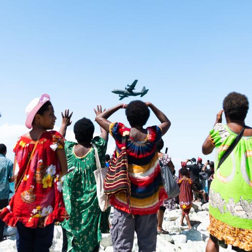 Crowds at Ela Beach watch as a Royal Australian Air Force C-130J Hercules conducts a fly past as part of the Ela Beach Air Show in Papua New Guinea.