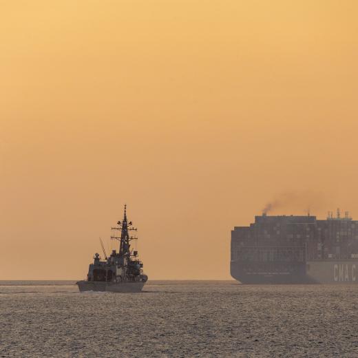 Japan Maritime Self-Defense Force destroyer and merchant vessel navigating the Malacca Strait 